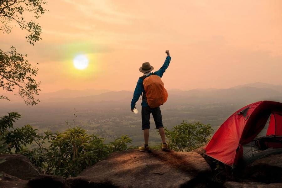 A person feeling succesful at the top of a mountain